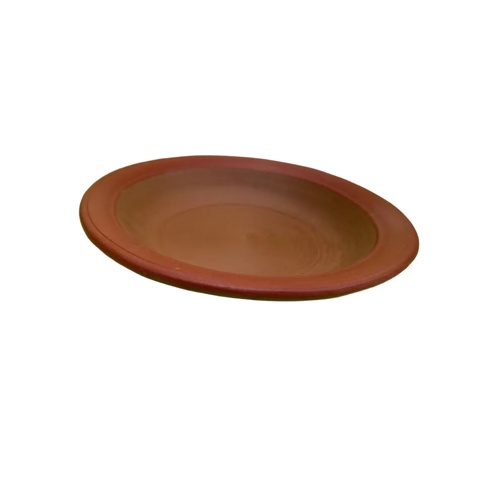 Red ceramic plate on a green surface