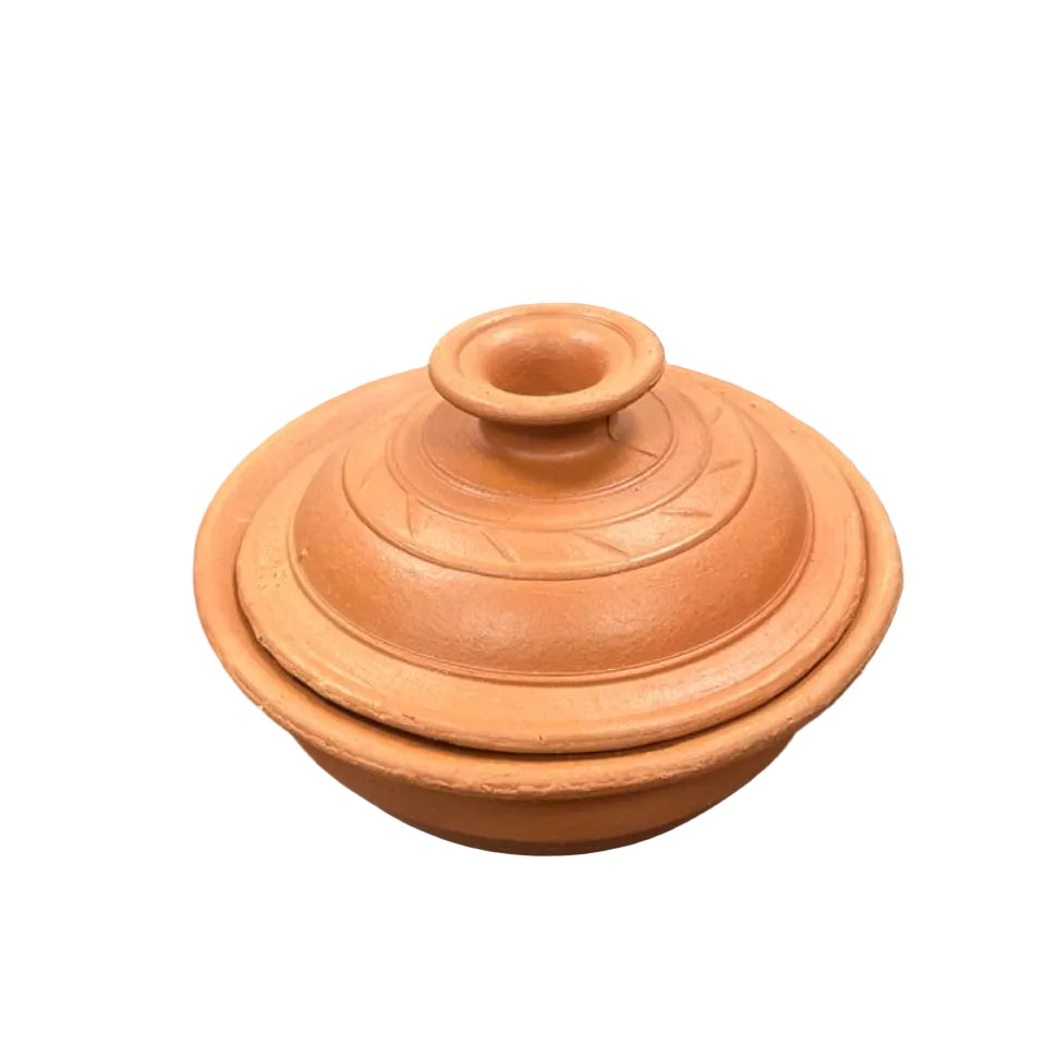 Terracotta pot with lid on a dark surface, possibly an office desk